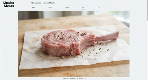 Thick-cut pale pink milk-fed veal tomahawk chop with bone on butcher wax paper